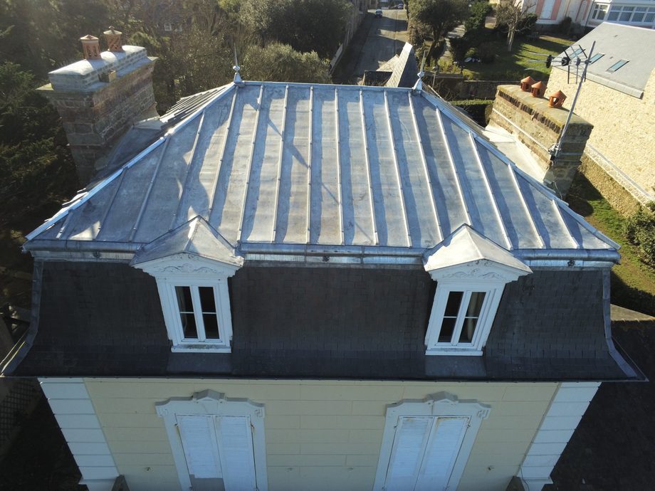 Vue aérienne d'une couverture à tasseaux terminée sur une maison bourgeoise, lucarnes à frontons habillés de zinc