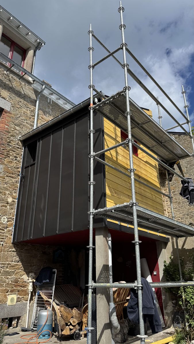 Façade côté cour entièrement sertie en zinc anthracite à joint debout, second pignon encore en bois sous l'échafaudage