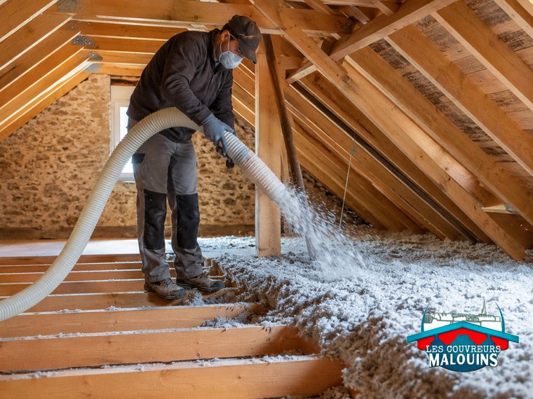 Soufflage d'ouate de cellulose sur le plancher de combles perdus, machine et flexible en action