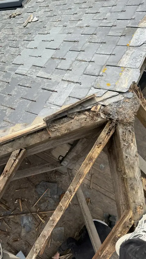 Ancienne couverture en ardoise à Saint-Malo : ardoises délavées, crochets rouillés, arêtier et charpente pourris à l'angle