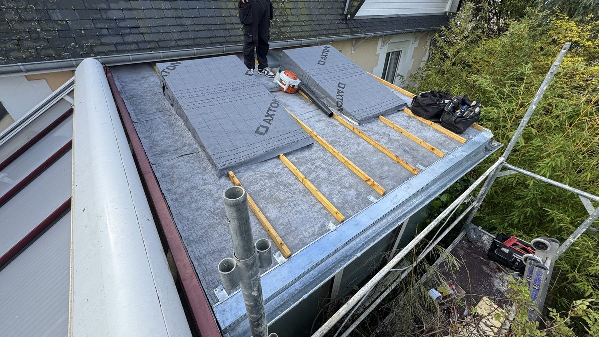Vue d'ensemble du support neuf avant le zinc : écran de sous-toiture, tasseaux, chevêtre, chéneau, verrière en polycarbonate voisine