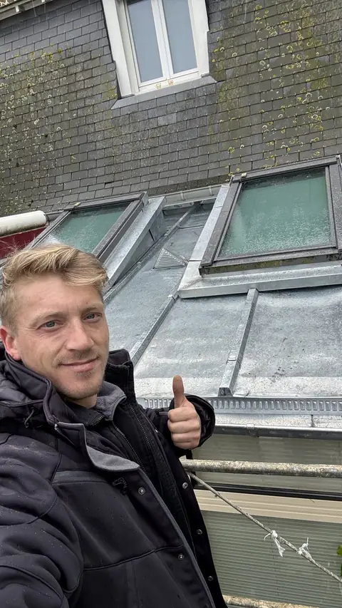 Willy Lambert pouce levé devant la couverture zinc à tasseaux terminée à Saint-Malo, deux fenêtres de toit neuves et chatière de ventilation