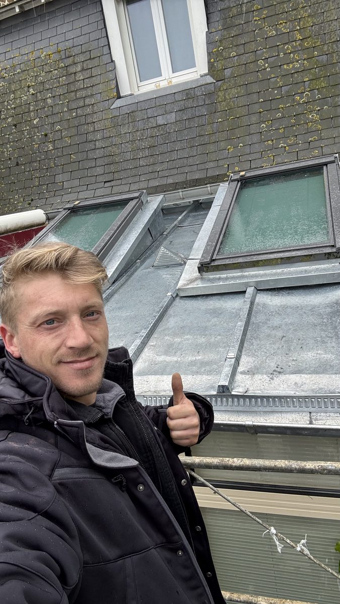 Willy Lambert pouce levé devant la couverture zinc à tasseaux terminée à Saint-Malo, deux fenêtres de toit neuves et chatière de ventilation