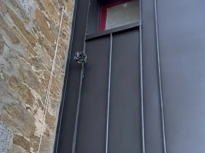 La rose en zinc fixée sur la façade de l'extension habillée de zinc anthracite, à Cancale