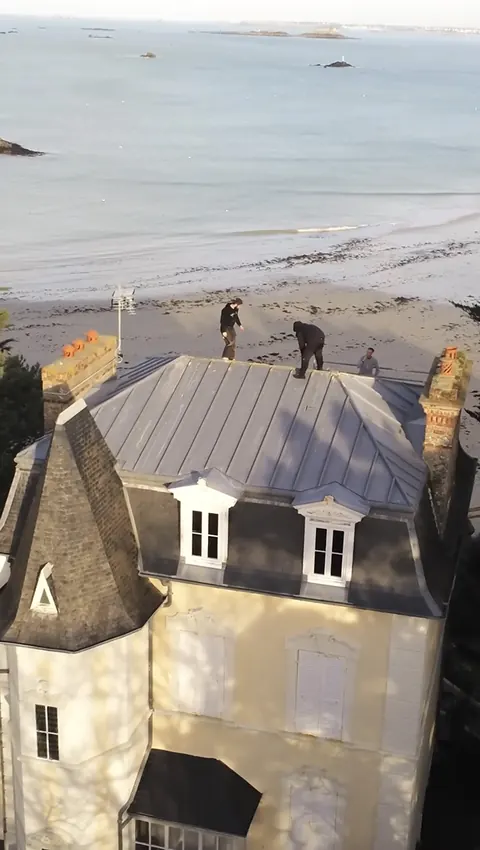 Vue au drone de la villa à la Mansart de Saint-Lunaire avant les travaux : l'équipe sur l'ancien terrasson en zinc, la plage et les îlots derrière